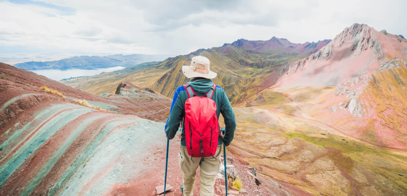 Hiker exploring the vibrant landscapes of Pallay Punchu on a full day adventure from Cusco