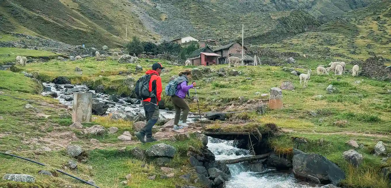Hikers crossing a stream on the Lares Trek, Peru.