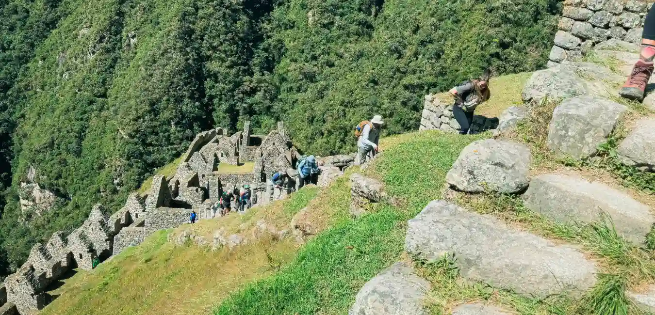 Inca Trail site Wiñaywayna, ancient terraces and stone structures surrounded by lush cloud forest.