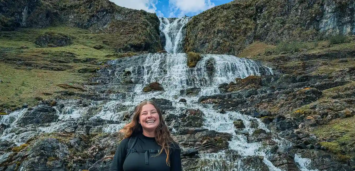 Traveler at a waterfall on the Lares Trek, Peru