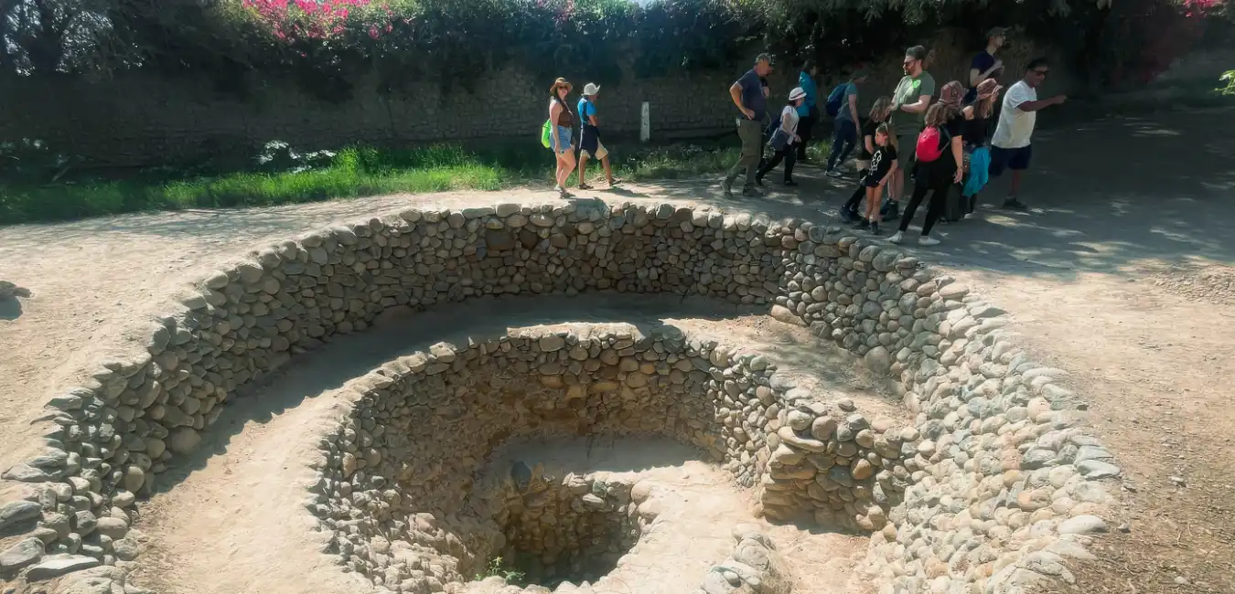 Tourists walking through the Cantalloc Aqueducts, part of the ancient Nazca Hydraulic System in the Peruvian desert.