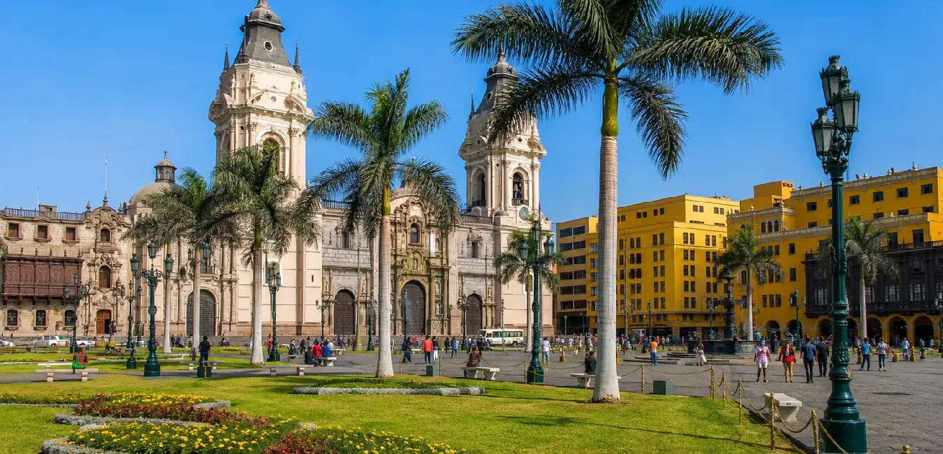 Lima Cathedral overlooking Plaza Mayor with palm trees and gardens in Lima, Peru.