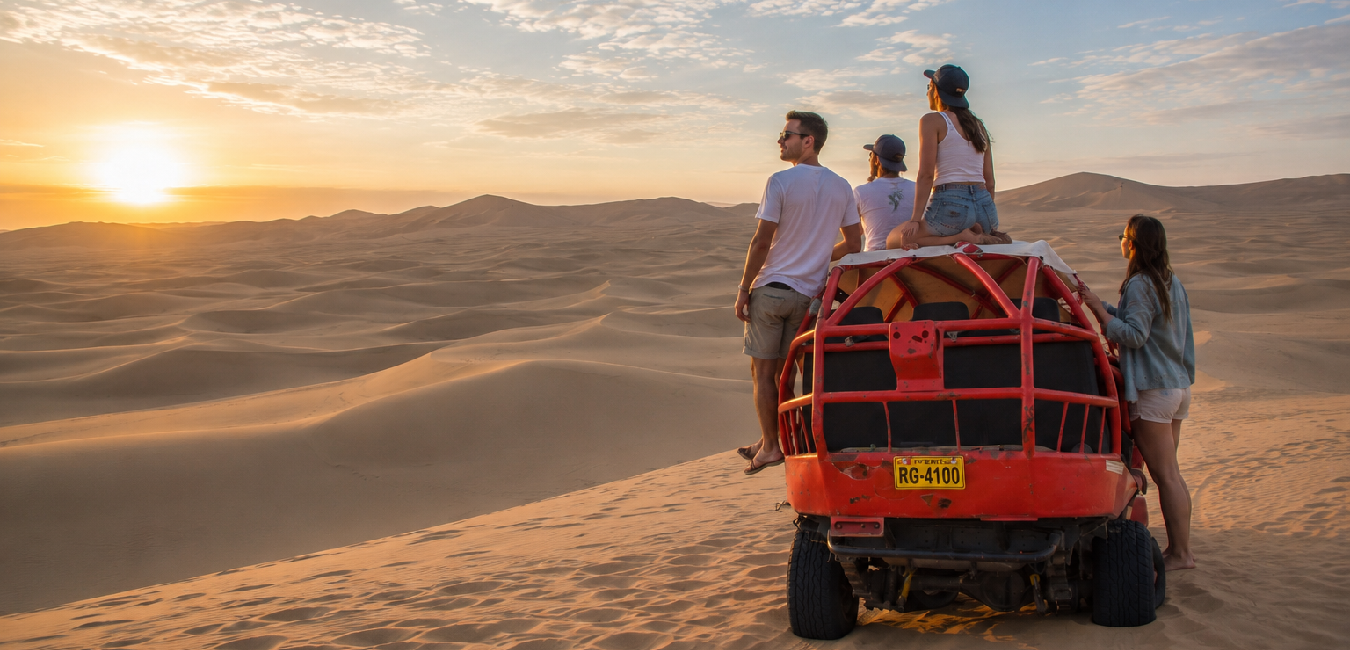 Travelers enjoying a dune buggy at sunset across the golden sand dunes of Huacachina Desert near Ica, Peru.