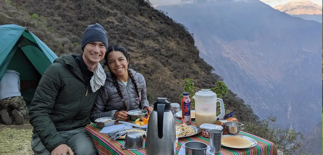 Tourists enjoying a picnic breakfast surrounded by Andean mountain scenery on the Choquequirao trek 