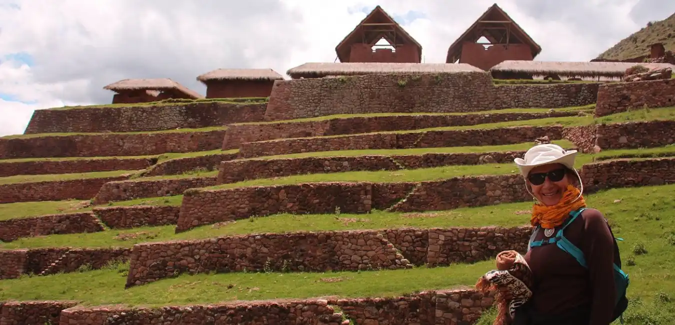 Traveler walking through the Huchuy Qosqo archaeological site with panoramic views 