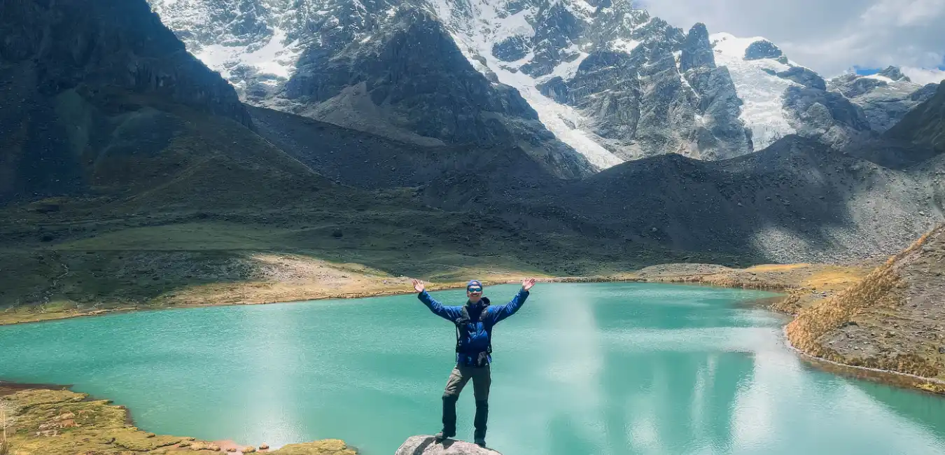 Traveler standing in front of the snow-capped Ausangate Mountain 