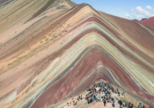 Rainbow Mountain surrounded by snow-capped peaks 