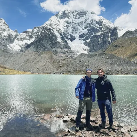Hikers walking beside Q’omer Q’ocha during the 7 Lagoons of Ausangate trek