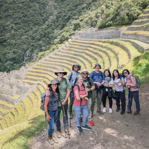 Hikers on the Inca Trail enjoying a panoramic view of the Wiñay Wayna archaeological site