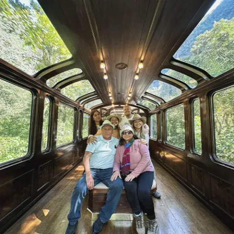 Family traveling in the Vistadome Observatory train to Machu Picchu